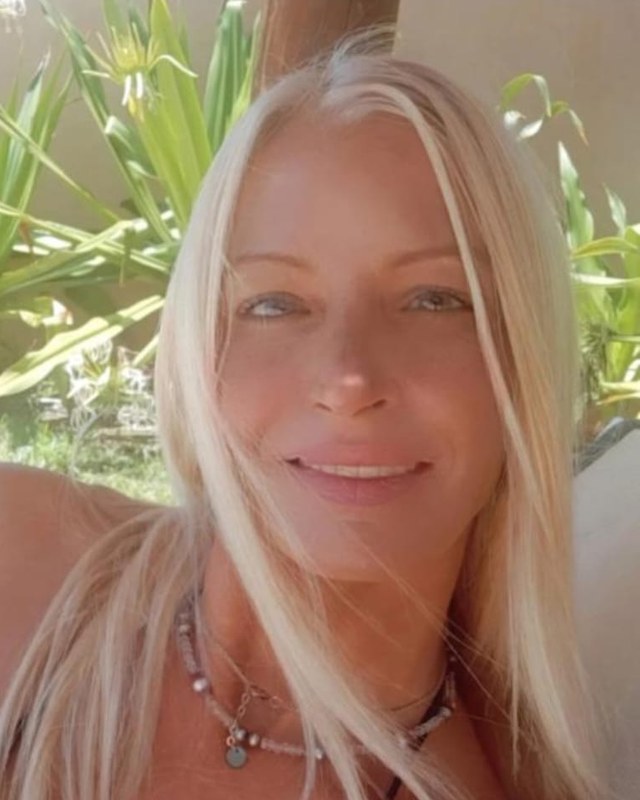 קארינה צור, מעצבת התכשיטים של KARINA, מחייכת בגינה ועונדת שרשרת חרוזים